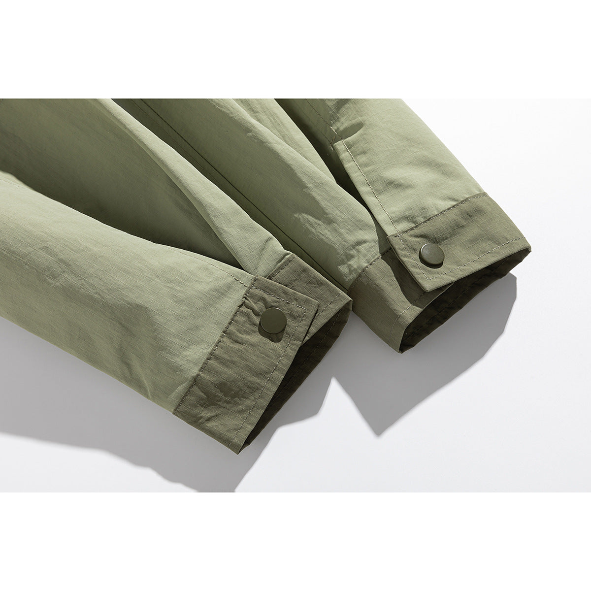 Close-up of the olive-green jacket's long sleeves and snap-button cuffs.