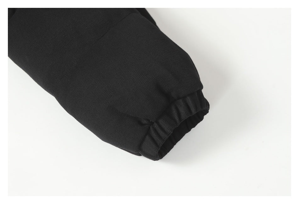 Close-up of a black sleeve ending in a gathered ribbed cuff.
