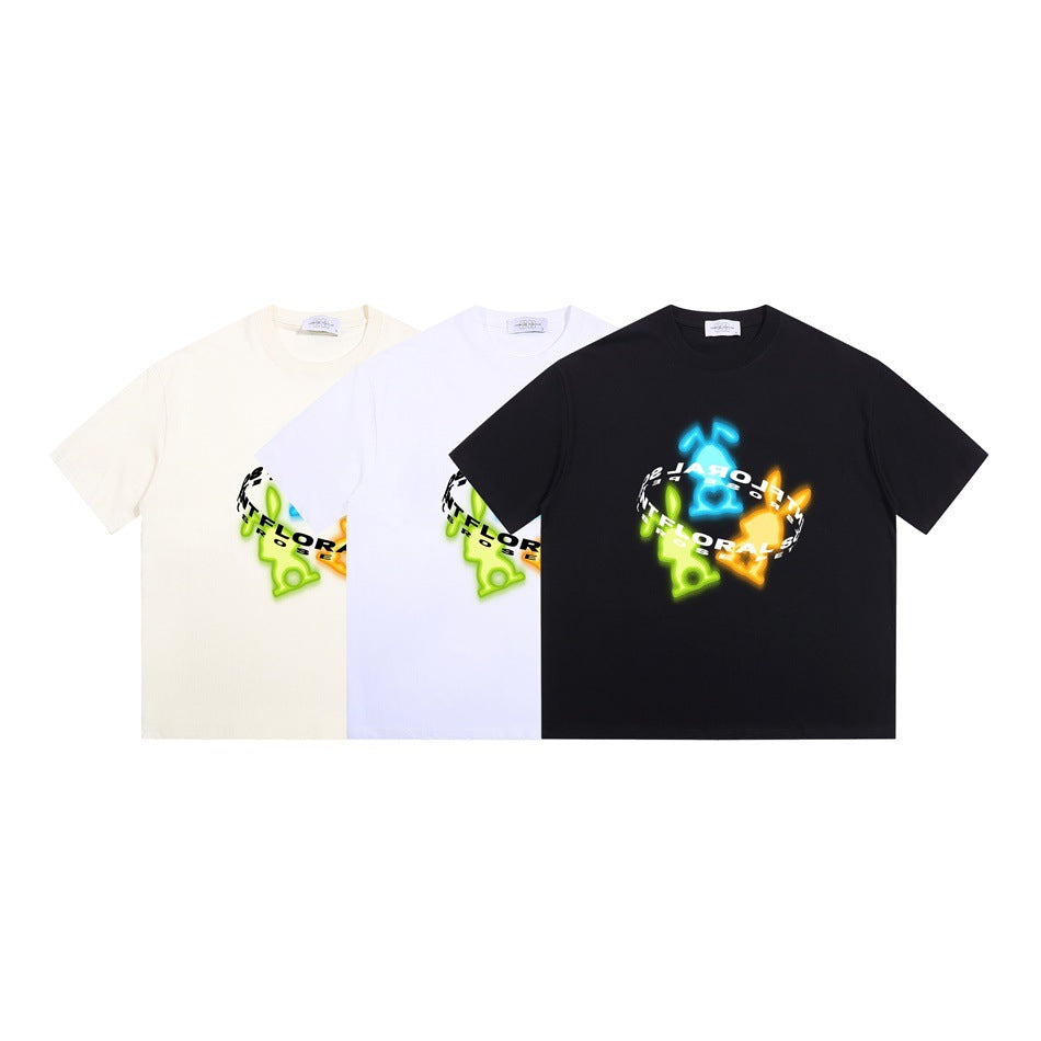 Three short-sleeve T-shirts in ivory, white, and black, each with a colorful chest graphic.