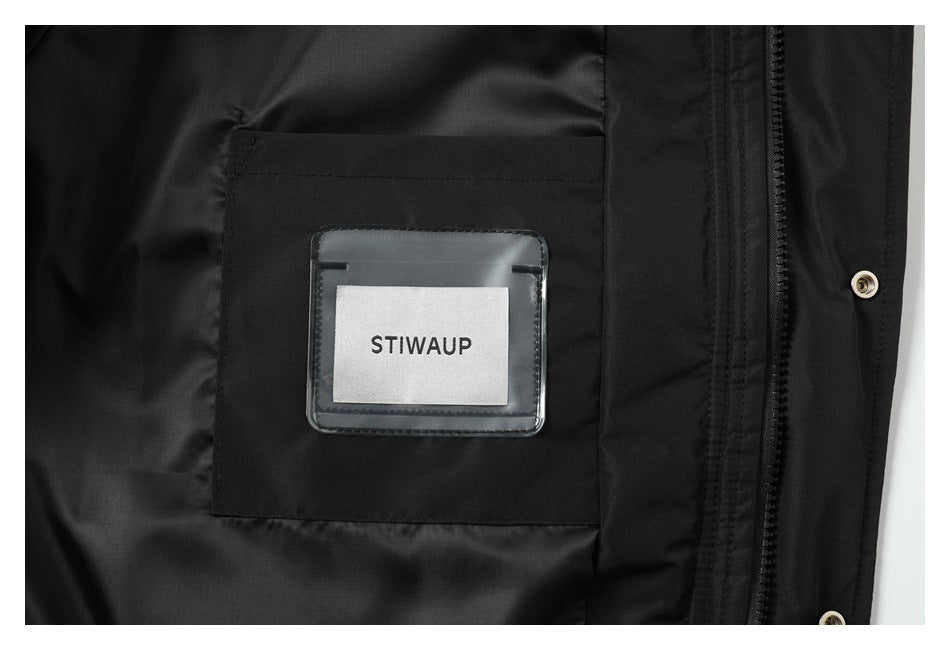 Interior detail of the black jacket showing a pocket, zipper, snap, and a label reading STIWAUP.