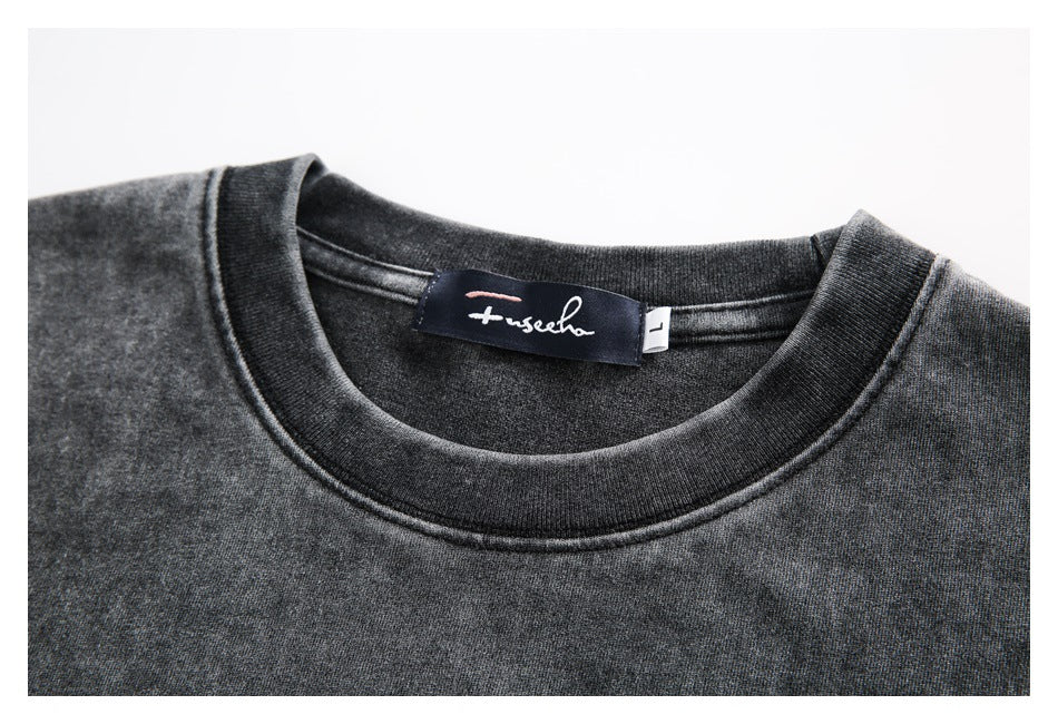 Close-up of a charcoal garment's ribbed crew neck, sewn-in brand label, and L size tag.