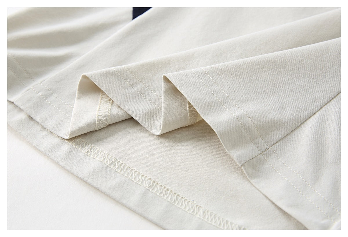Close-up of the ivory fabric and double-stitched hem with the seam finish visible.