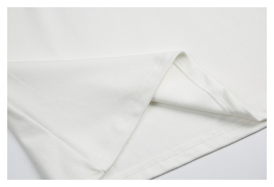 White garment hem folded back to show the inner seam and stitching.