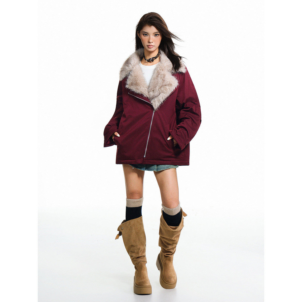 Model wearing a burgundy oversized jacket with an asymmetrical zipper and a wide pale fur collar.