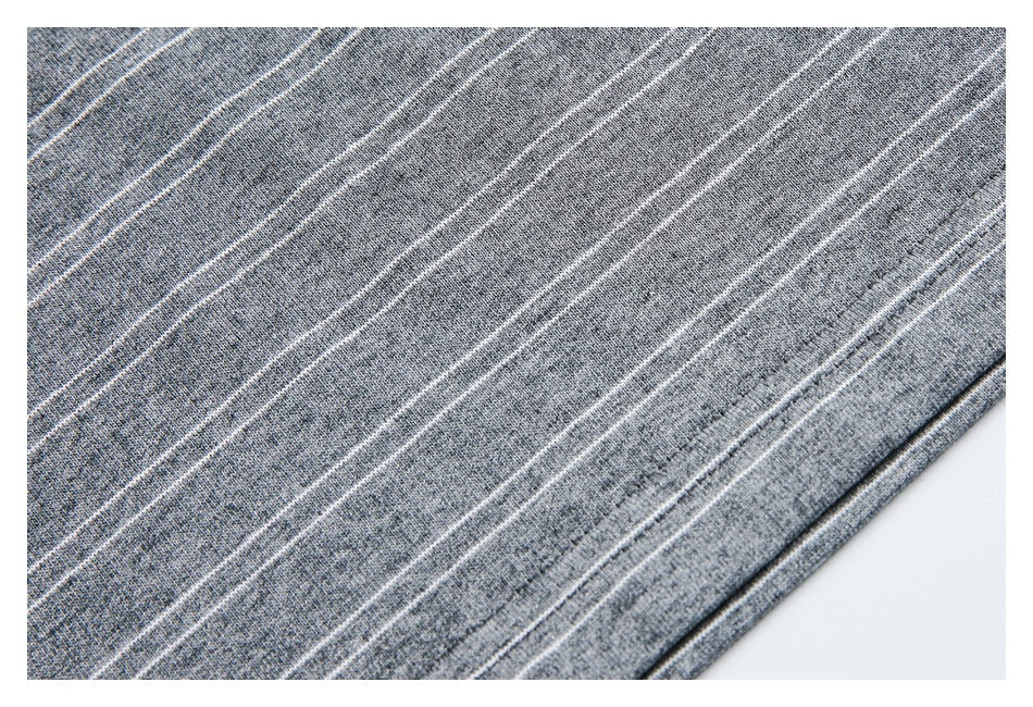 Close-up of gray striped knit fabric and the garment's stitched hem.