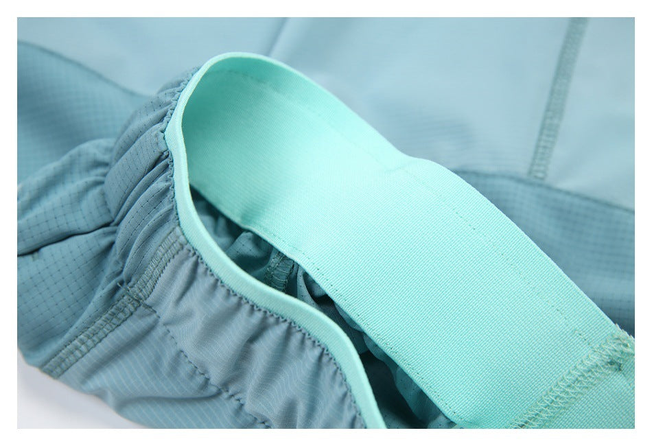 Close-up of an aqua elastic band over gathered light blue fabric with stitching.
