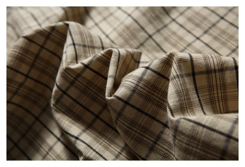 Close-up of beige and brown plaid fabric draped into folds.
