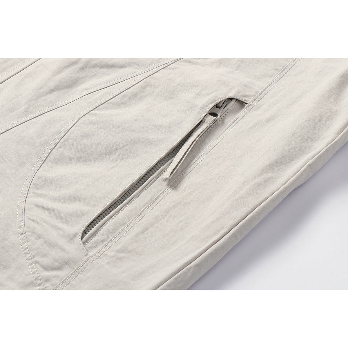 Close-up of an off-white jacket's slanted zip pocket and double-stitched seams.