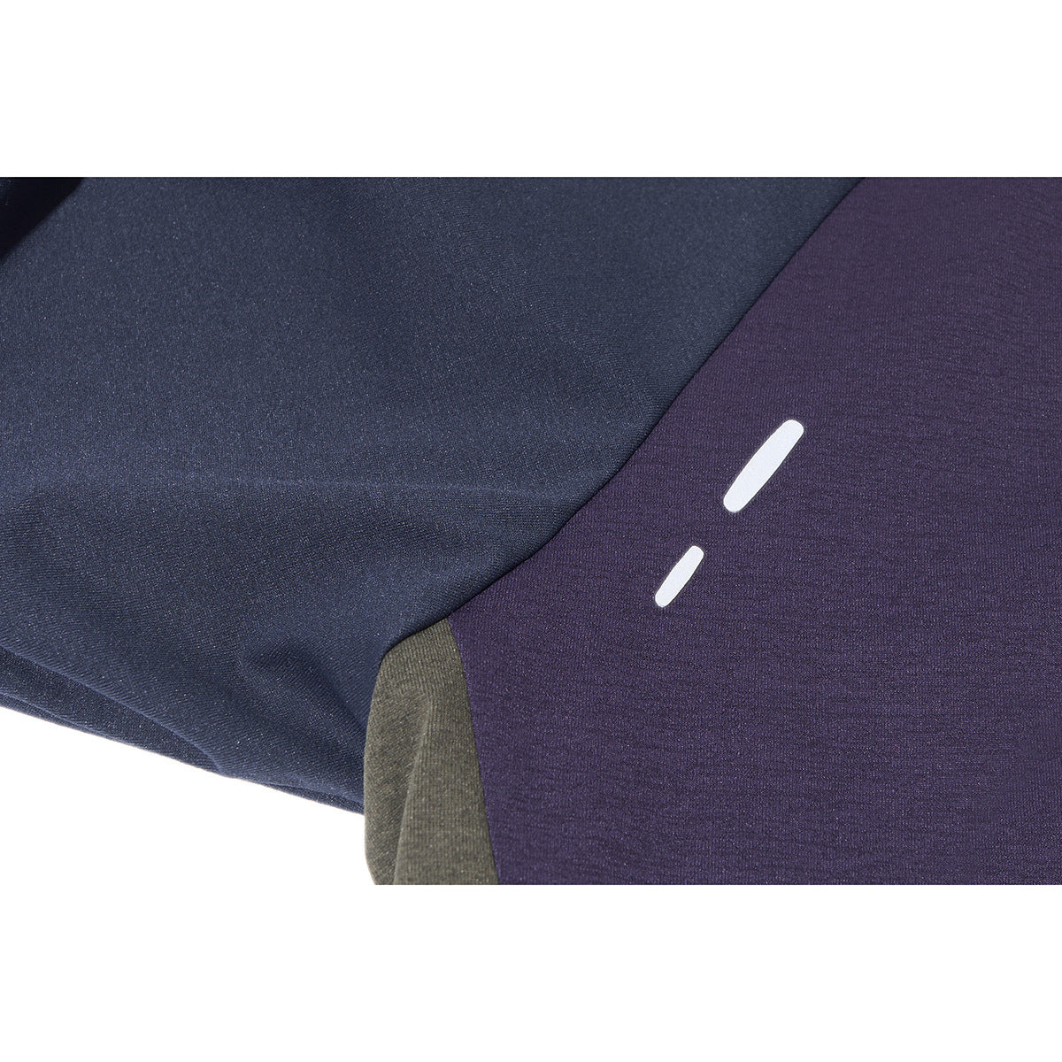 Close-up of two white reflective-looking bars on the purple and navy fabric of a top.