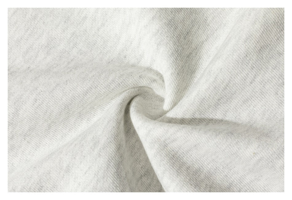 Close-up of light gray fabric gathered into a spiral, showing its fine knit texture.