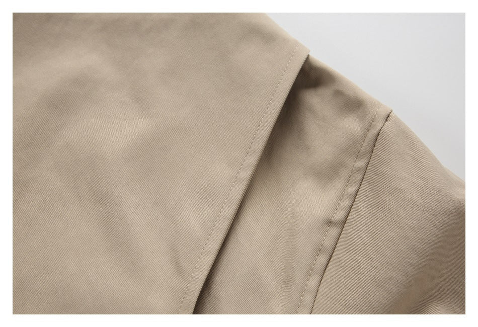 Close-up of a beige garment shoulder seam and overlapping fabric panels.