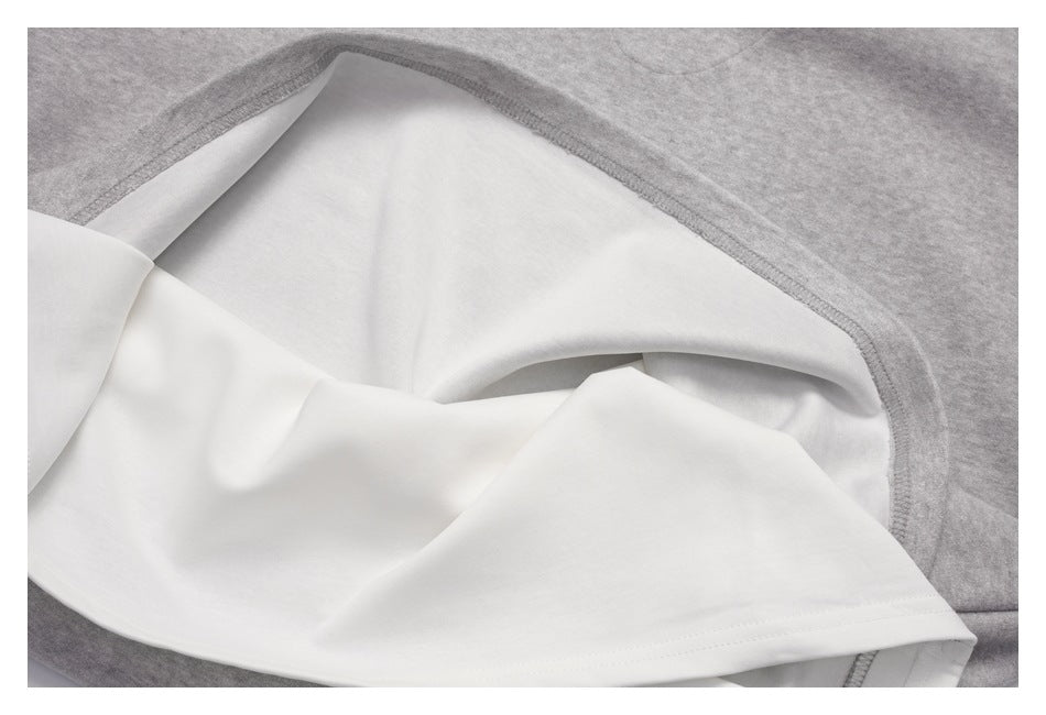 Close-up of a gray garment turned inside out, showing white inner fabric and stitched edge.