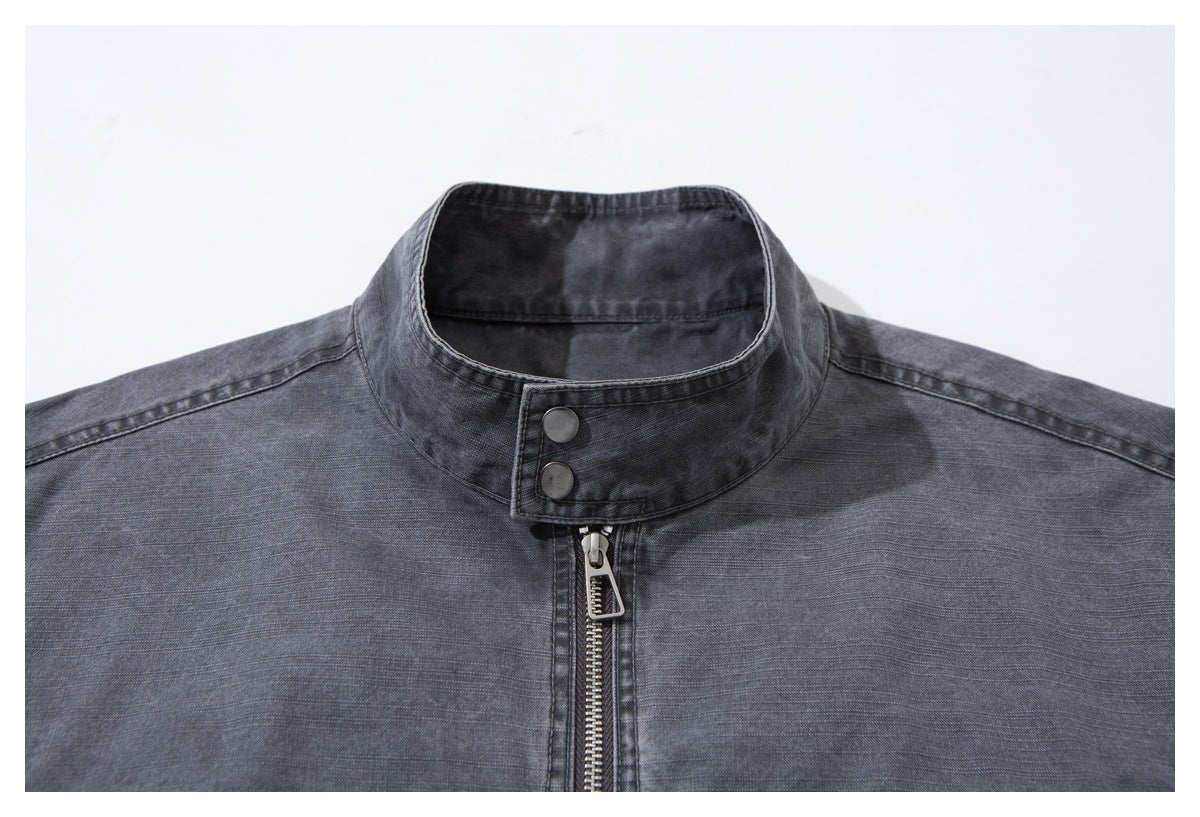 Close-up of a charcoal-gray jacket's stand collar, two snaps, and front zipper.