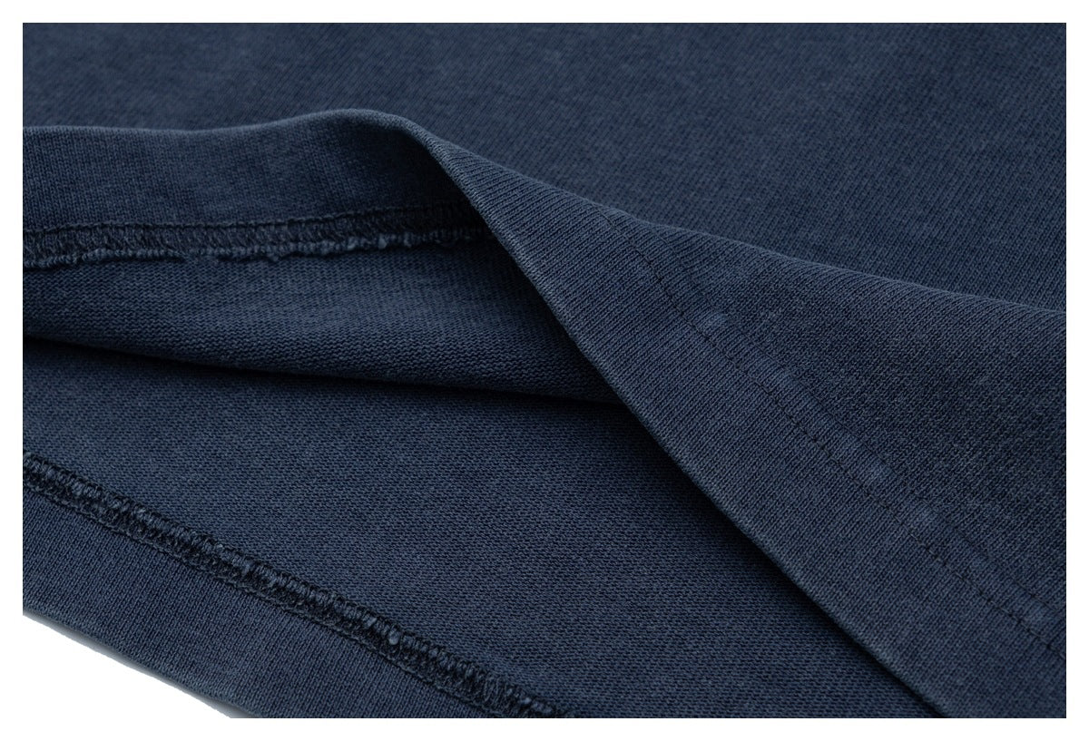 Close-up of the navy shirt's inside fabric and stitched hem seam.