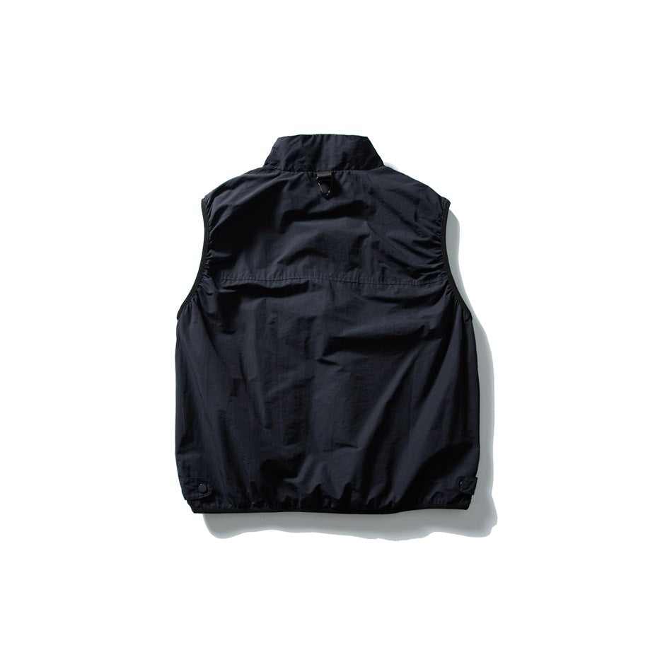Back view of a black sleeveless vest with a high collar, back yoke seam, and snap details near the hem.