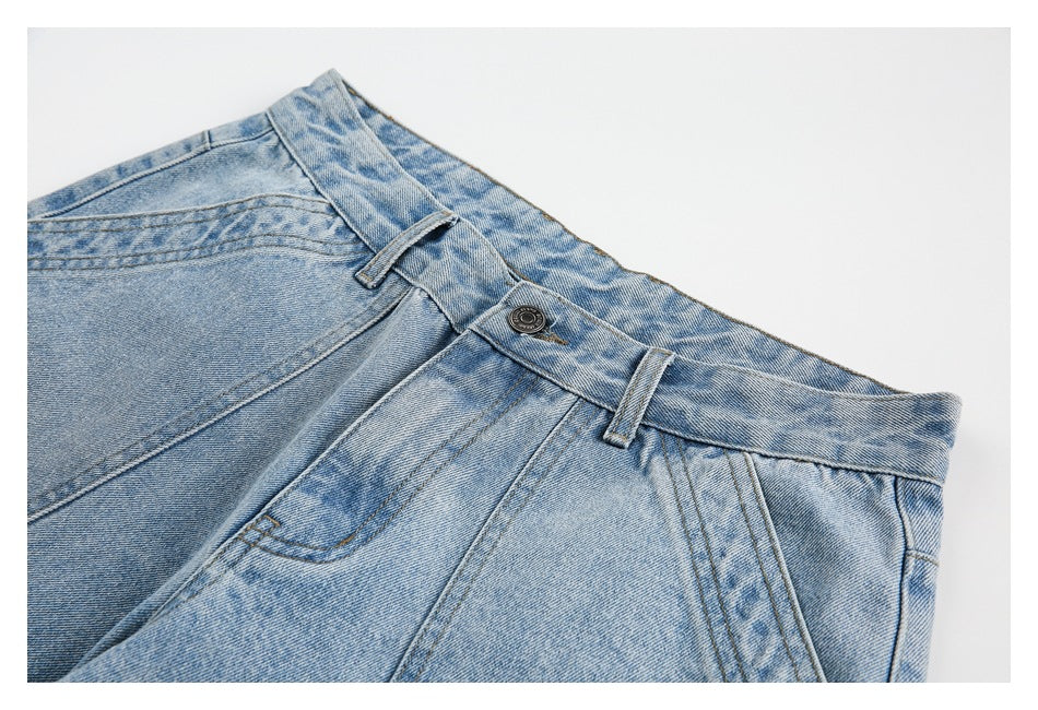 Close-up of the light blue denim shorts' waistband, button, belt loops and pleated front pocket area.