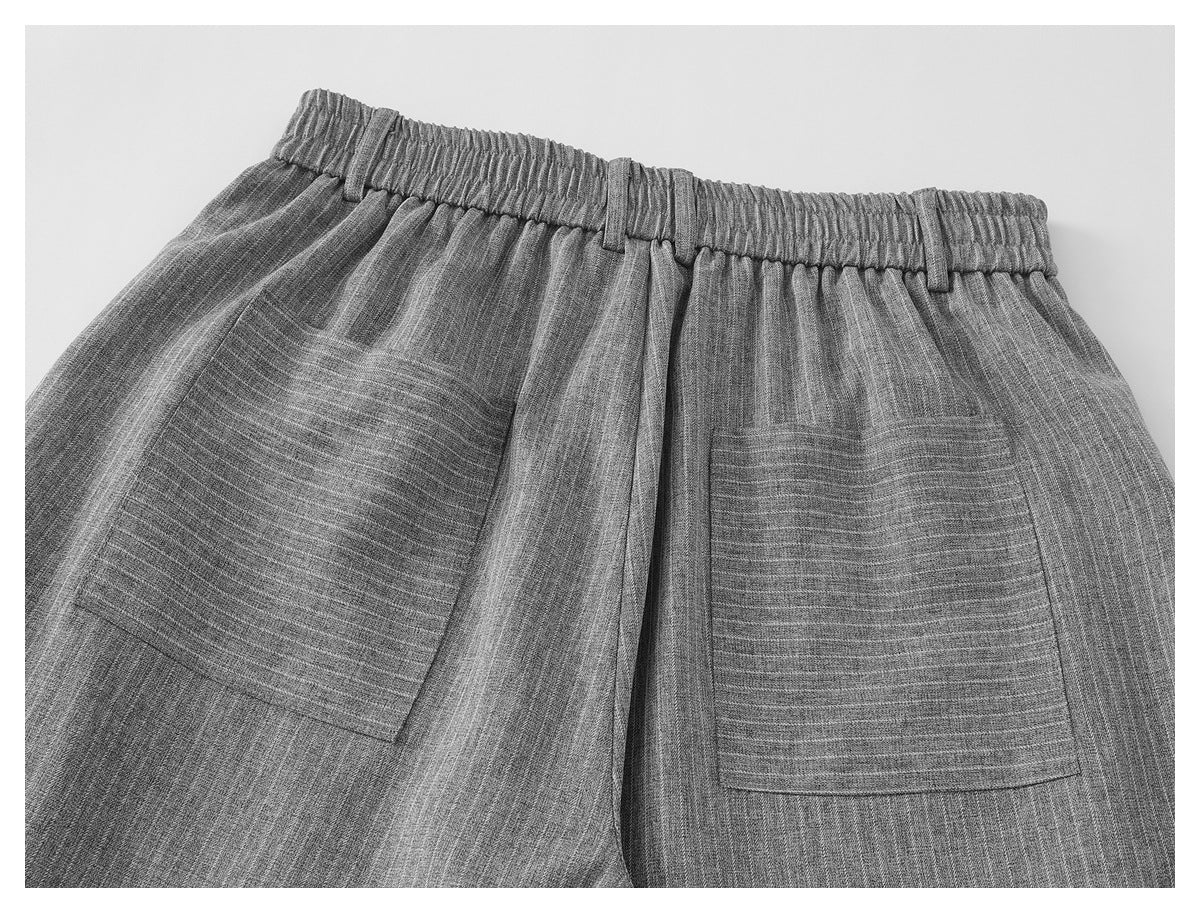 Rear view of gray pinstriped trousers with an elastic waistband, belt loops, and two patch pockets.