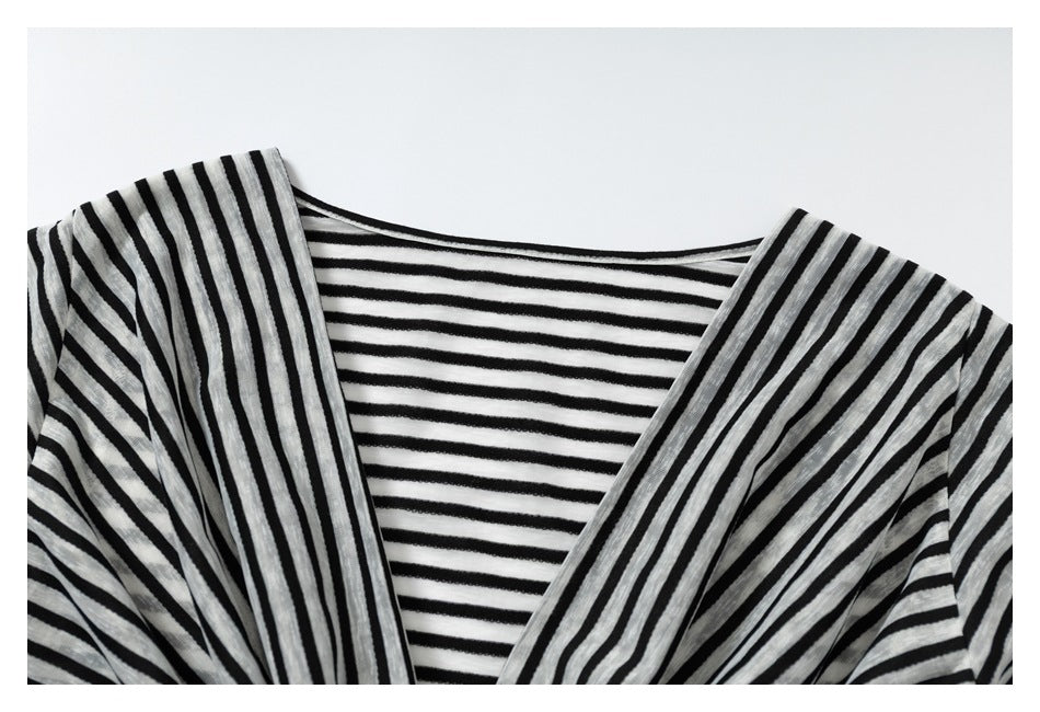 Close-up of a black-and-white striped garment showing a V-shaped neckline and contrasting stripe directions.