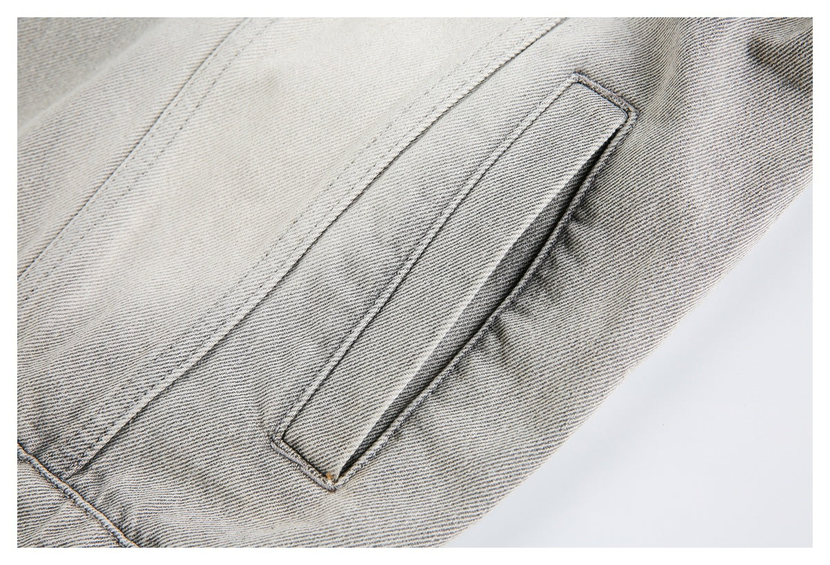 Close-up of a narrow welt pocket on pale gray washed denim.