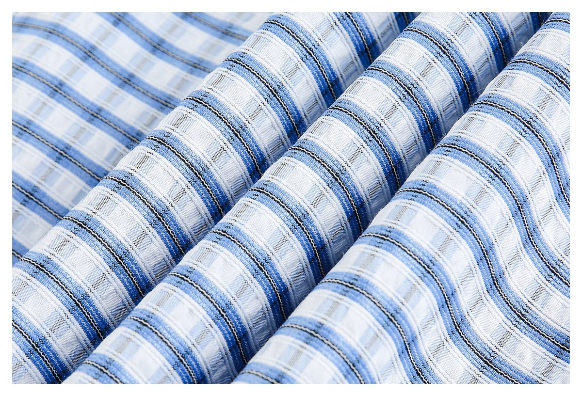 Close-up of blue, gray, and white plaid fabric draped in soft folds.