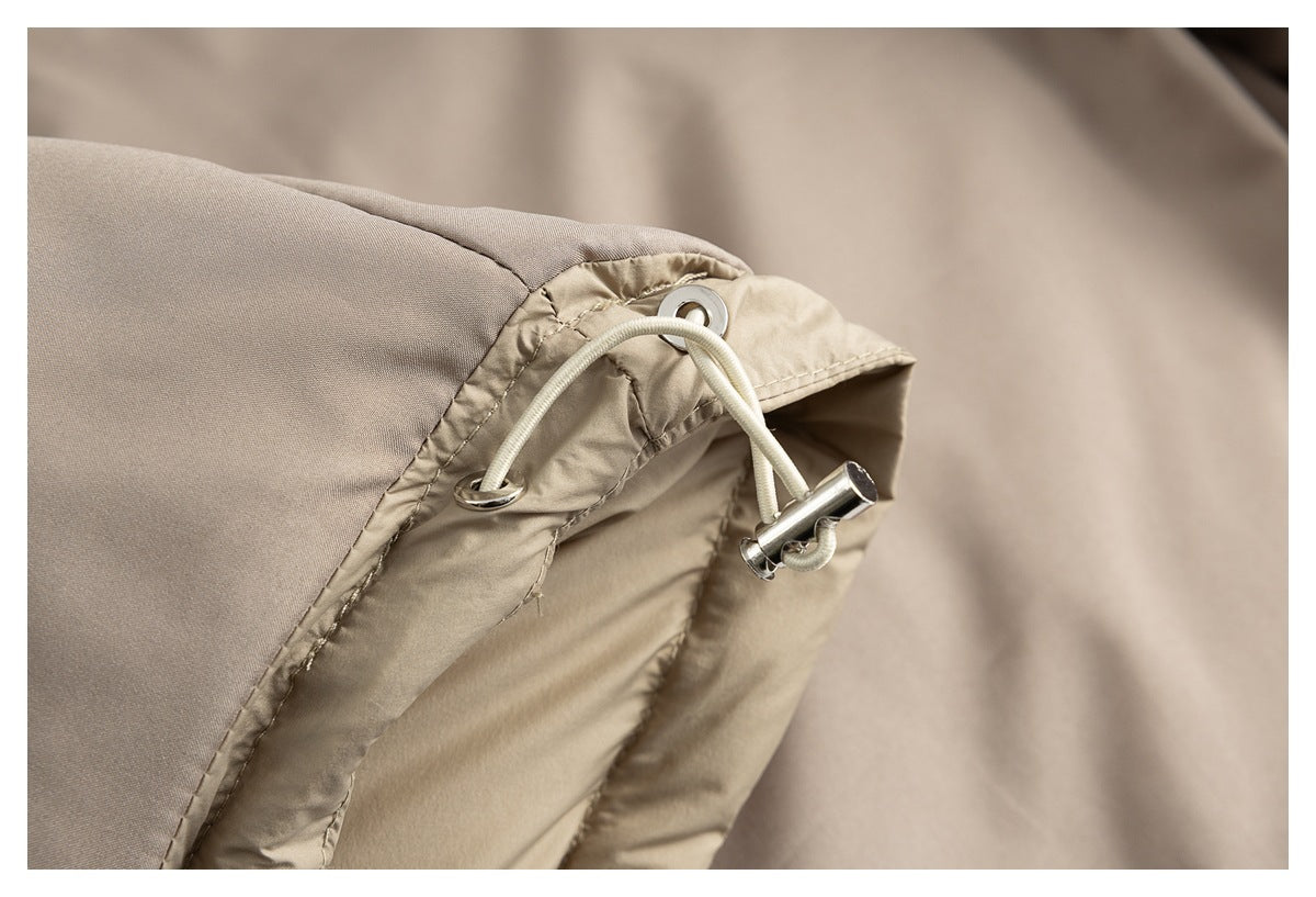 Close-up of a beige jacket hood edge with metal eyelets and an adjustable drawcord.