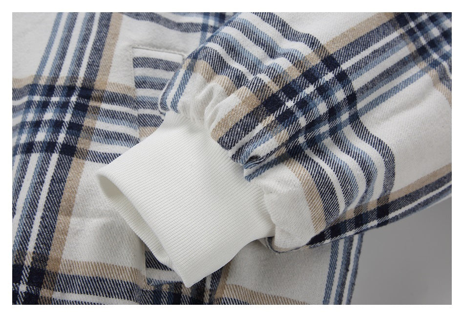 Close-up of the plaid jacket sleeve gathered into a wide white rib-knit cuff.