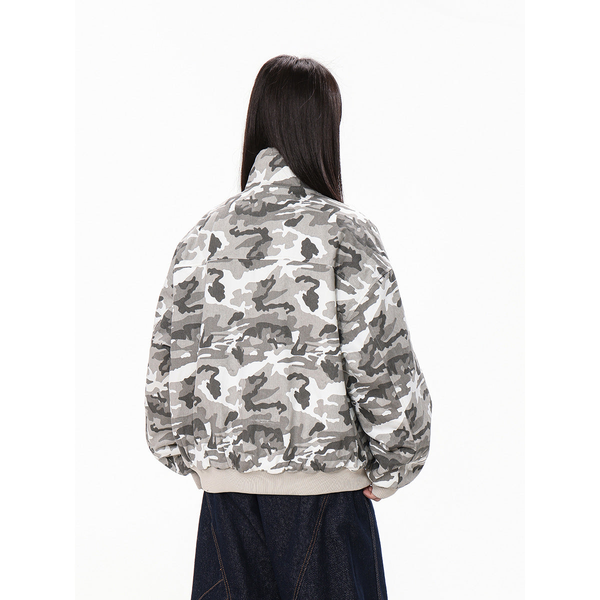 Rear view of a model wearing an oversized gray-and-white camouflage jacket with a ribbed hem and cuffs.