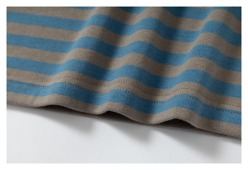 Close-up of blue and taupe stripes and the stitched lower hem of a garment.
