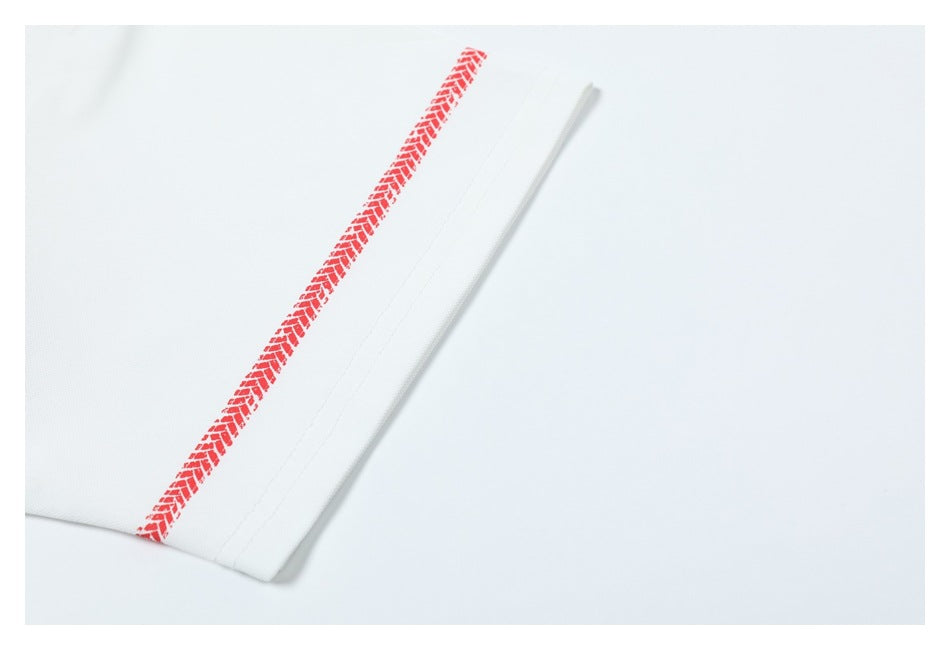Close-up of a white shirt hem with a red tire-track stripe and stitched edge.