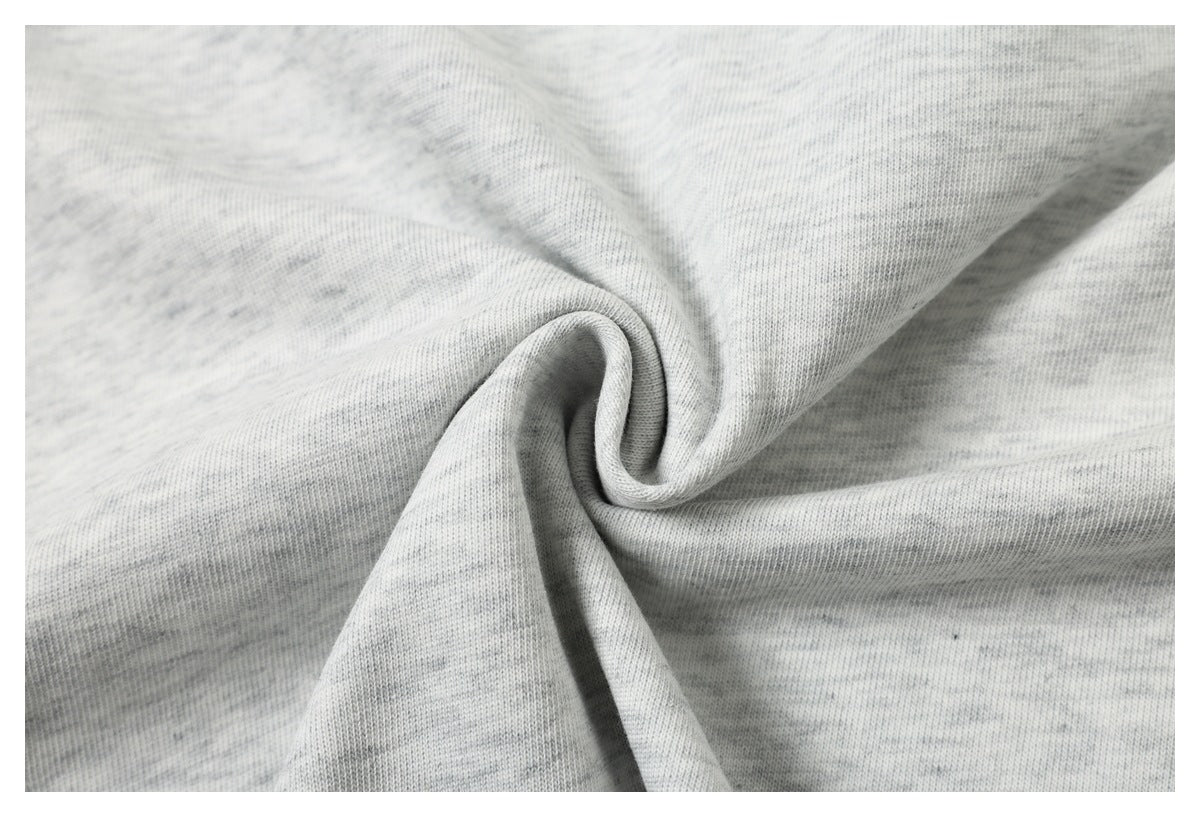 Close-up of light gray heathered knit fabric gathered into a spiral fold.