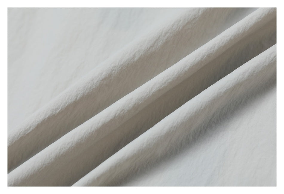Close-up showing the softly crinkled texture of light gray jacket fabric.