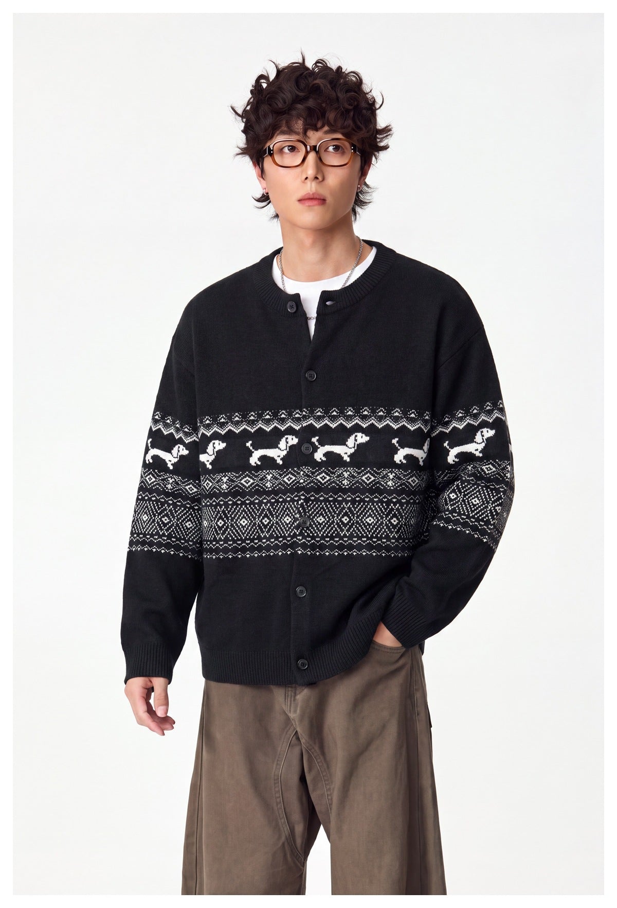 Model wearing a black button-front cardigan with white dog motifs and geometric bands across the chest and sleeves.