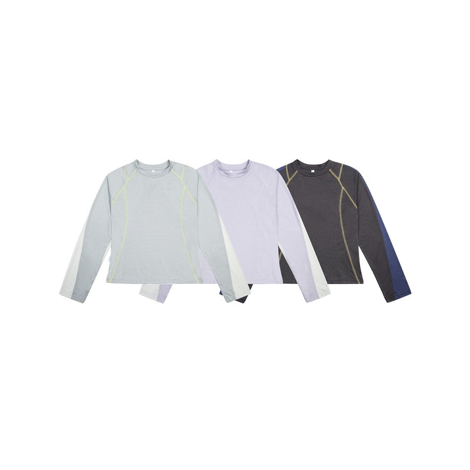 Three long-sleeve tops shown together in pale blue-gray, lavender, and charcoal, each with contrasting seam accents.