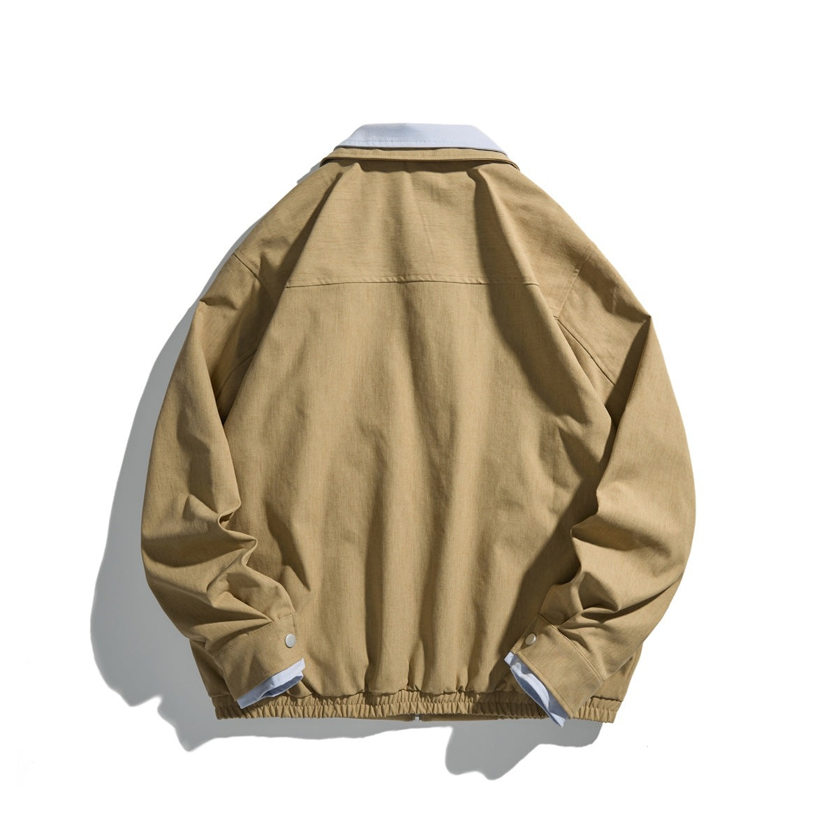 Back view of a tan jacket with a pale blue collar, snap cuffs, and an elasticized hem.