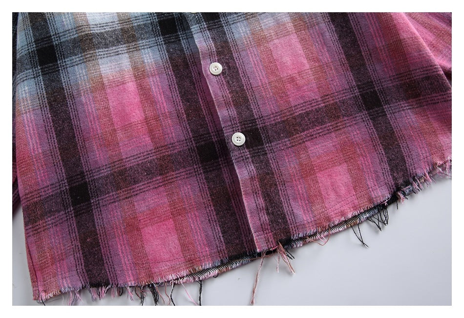 Close-up of the pink-and-black plaid lower hem, white buttons and frayed edge.
