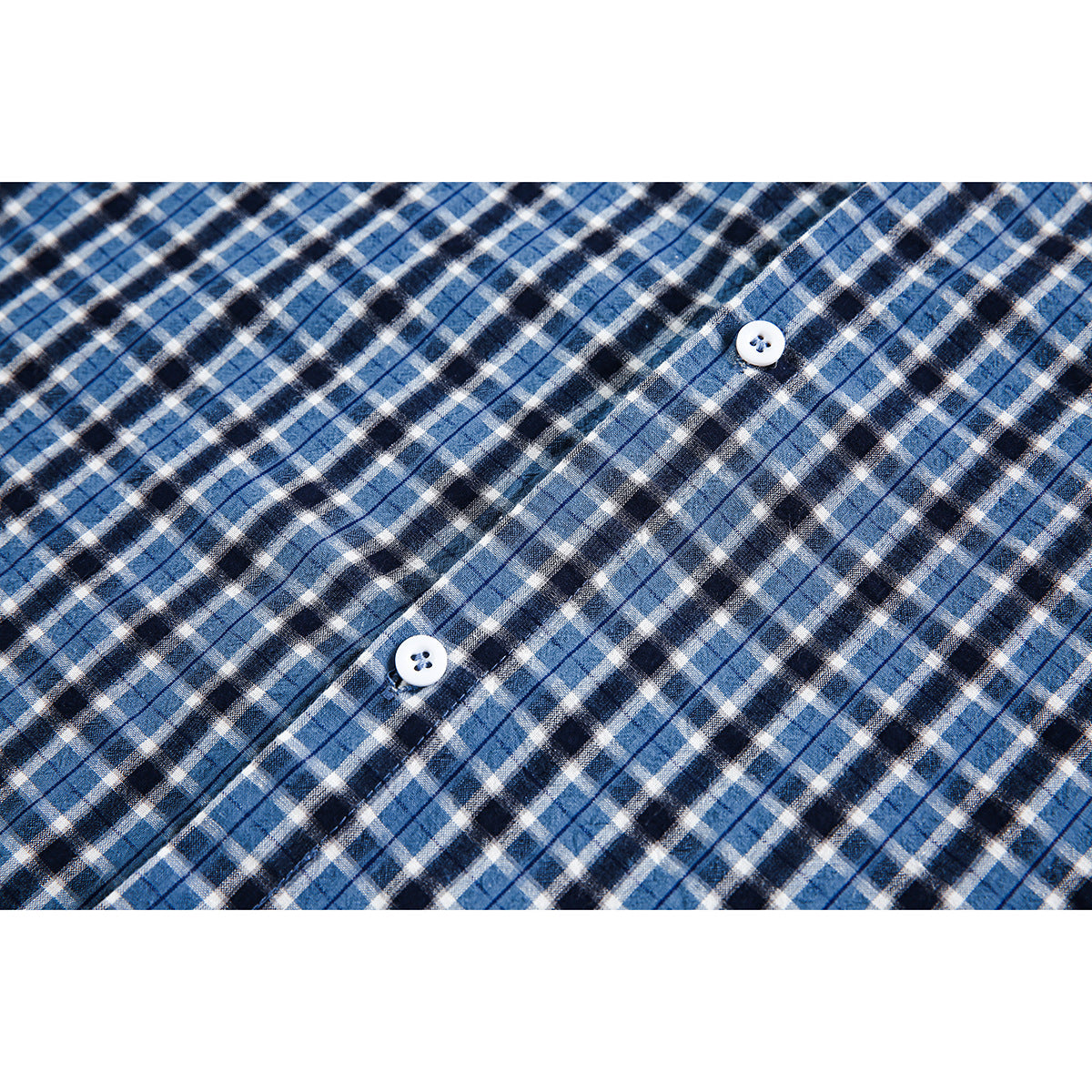 Close-up of blue, black, and white plaid shirt fabric with two white buttons.
