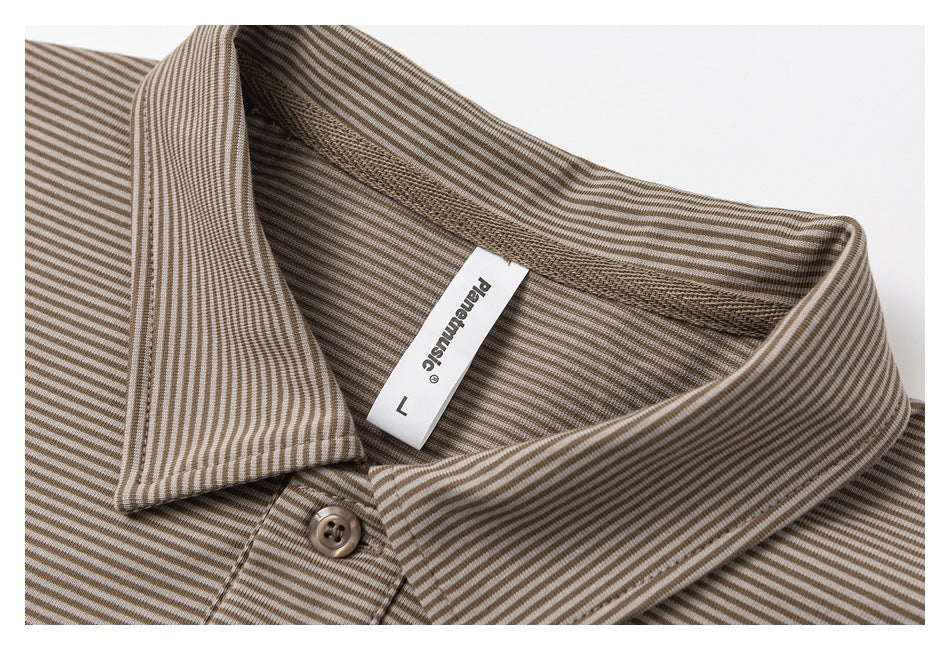 Close-up of a taupe striped polo collar, button, and attached neck label.