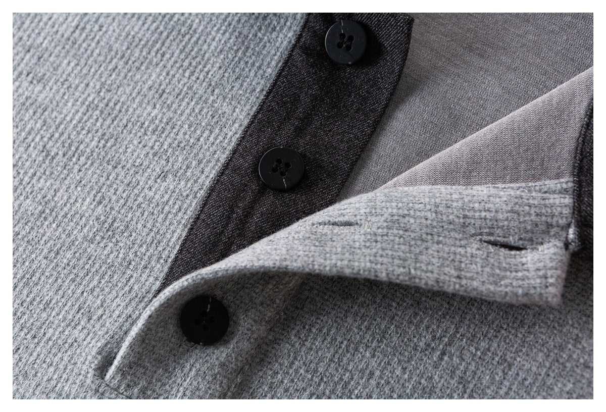 Close-up of a gray shirt's dark button placket and folded light gray cuff.