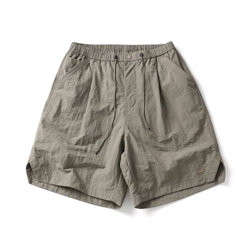 Light khaki knee-length shorts with drawcord waist, pleats and side pockets, flat lay front view