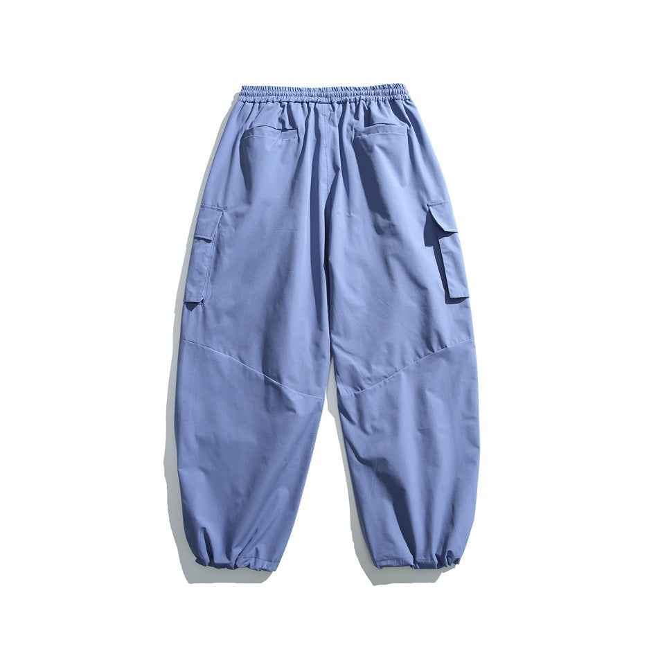 Back view of slate blue jogger pants with an elastic waist, two rear pockets, side cargo pockets and elastic cuffs.