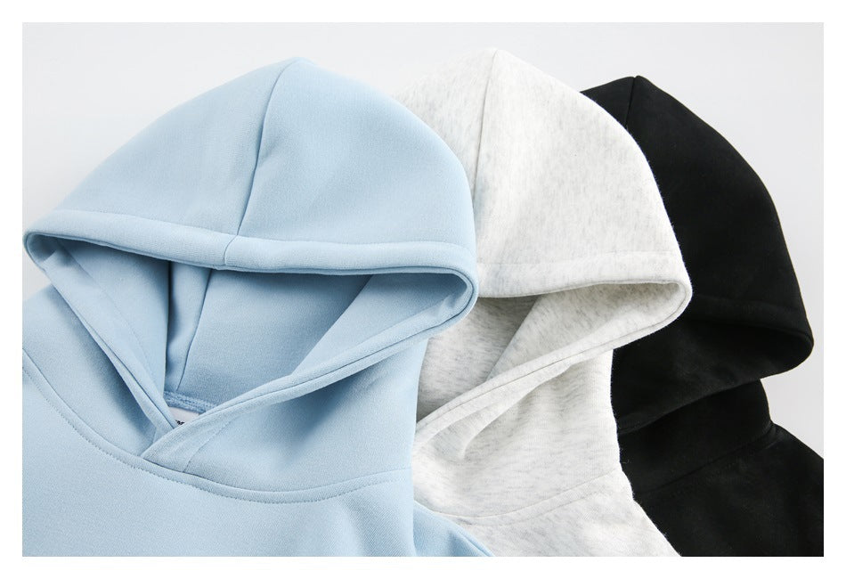 Close-up of pullover hoodie hoods in light blue, heather gray, and black.