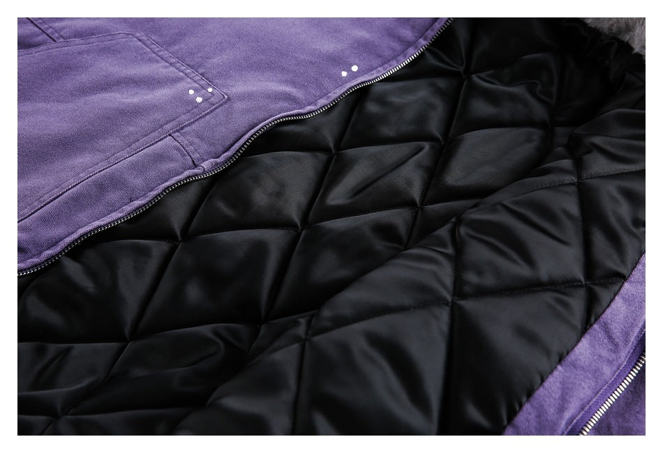 Close-up of a purple garment opened to show its black diamond-quilted lining and zipper.