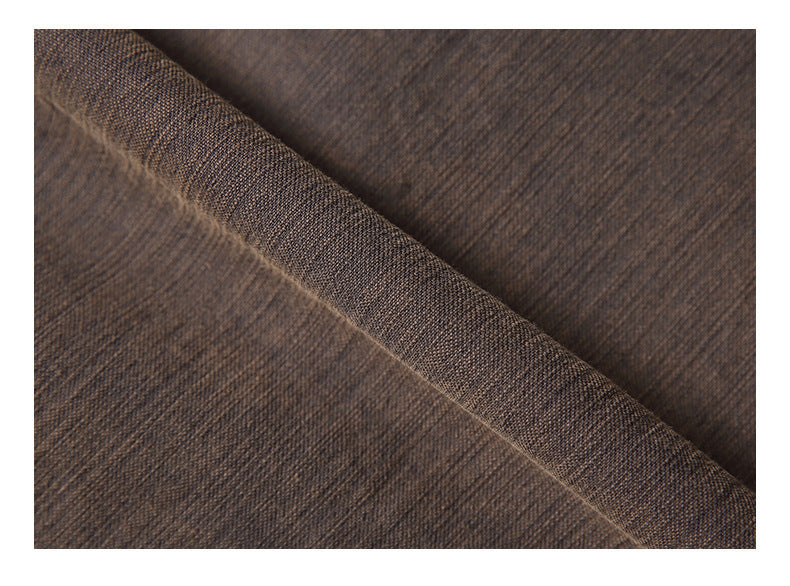 Close-up of dark brown fabric showing its fine weave and a folded edge.
