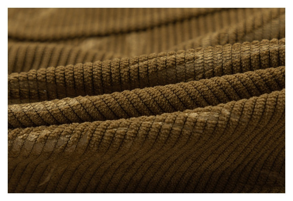 Macro view of the thick, raised ribs of brown corduroy fabric.