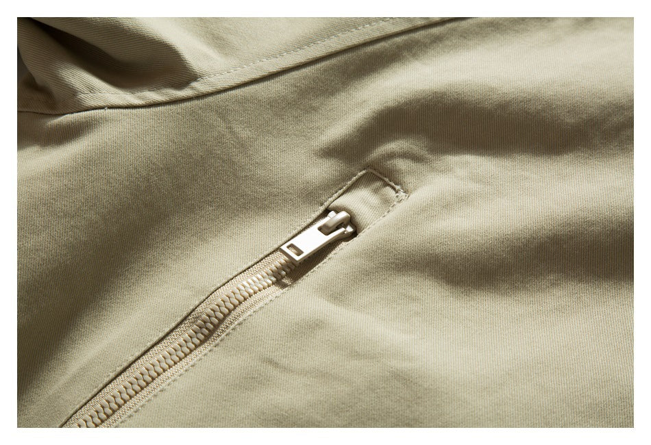 Close-up of a beige garment with a diagonal zipper and light-colored zipper pull.
