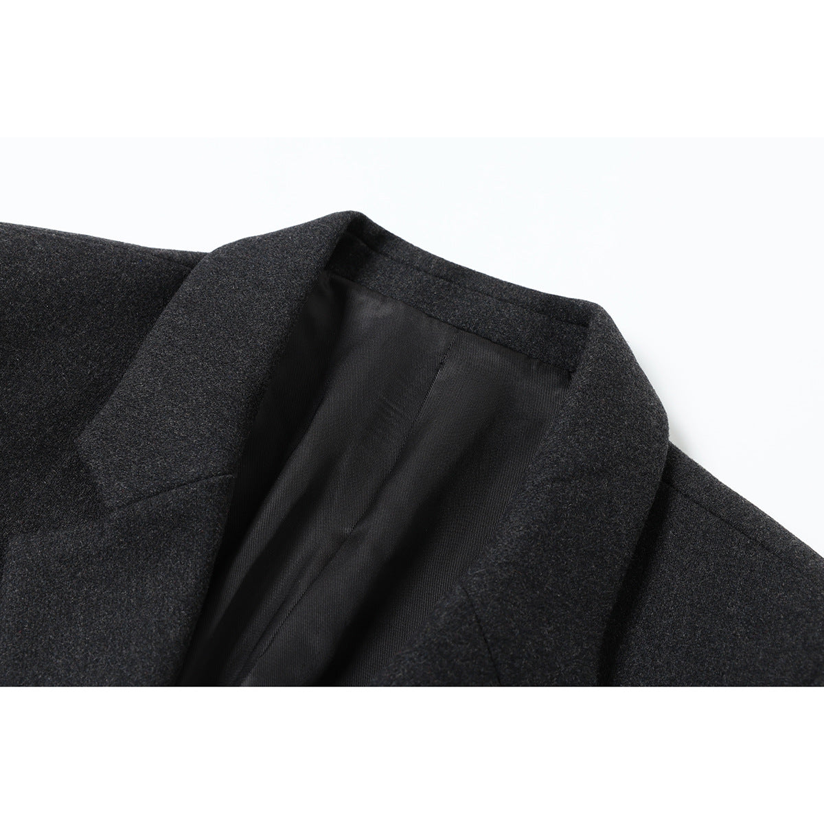 Close-up of a charcoal gray coat’s notched lapel and black inner lining.