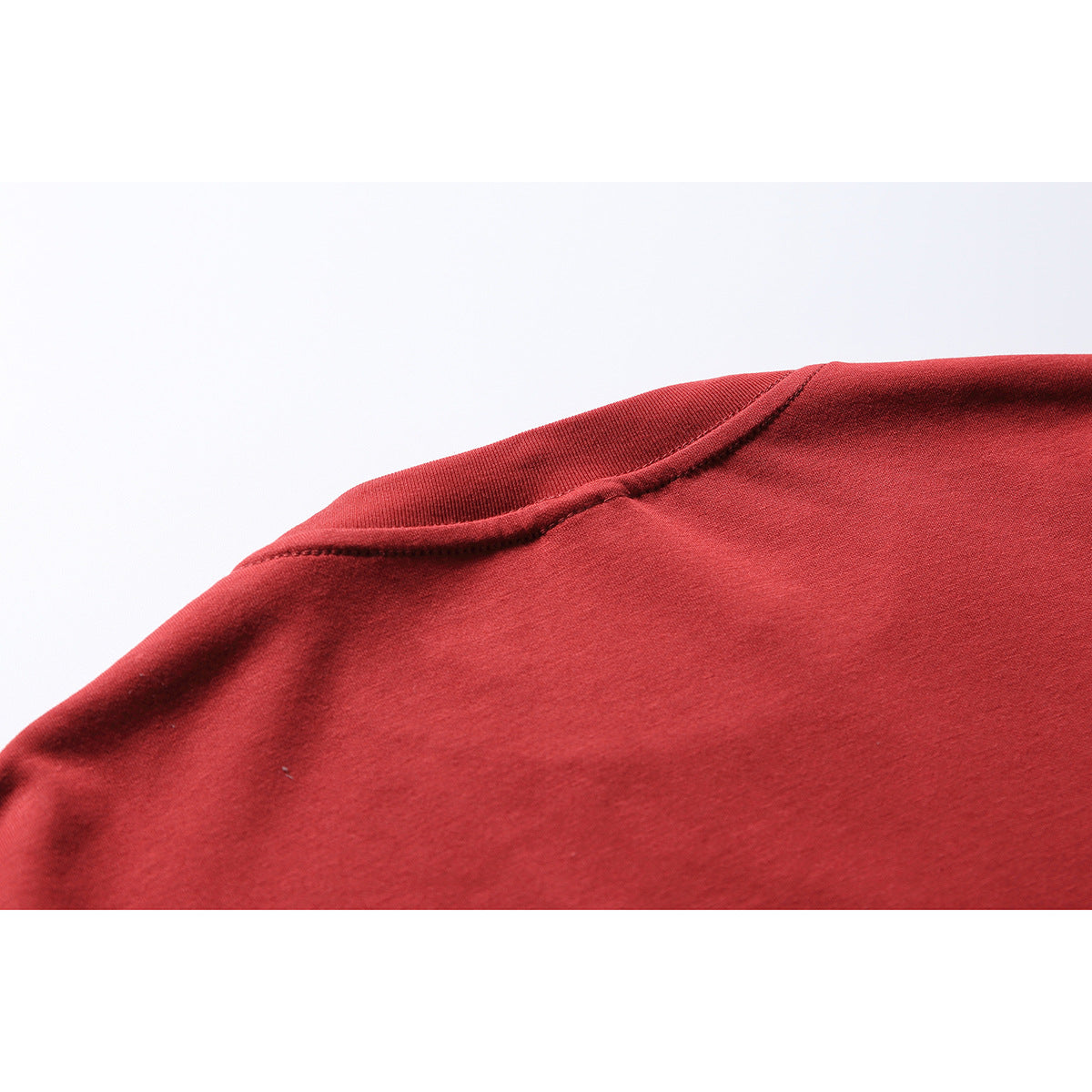 Close-up of the red T-shirt's shoulder seam and fabric.