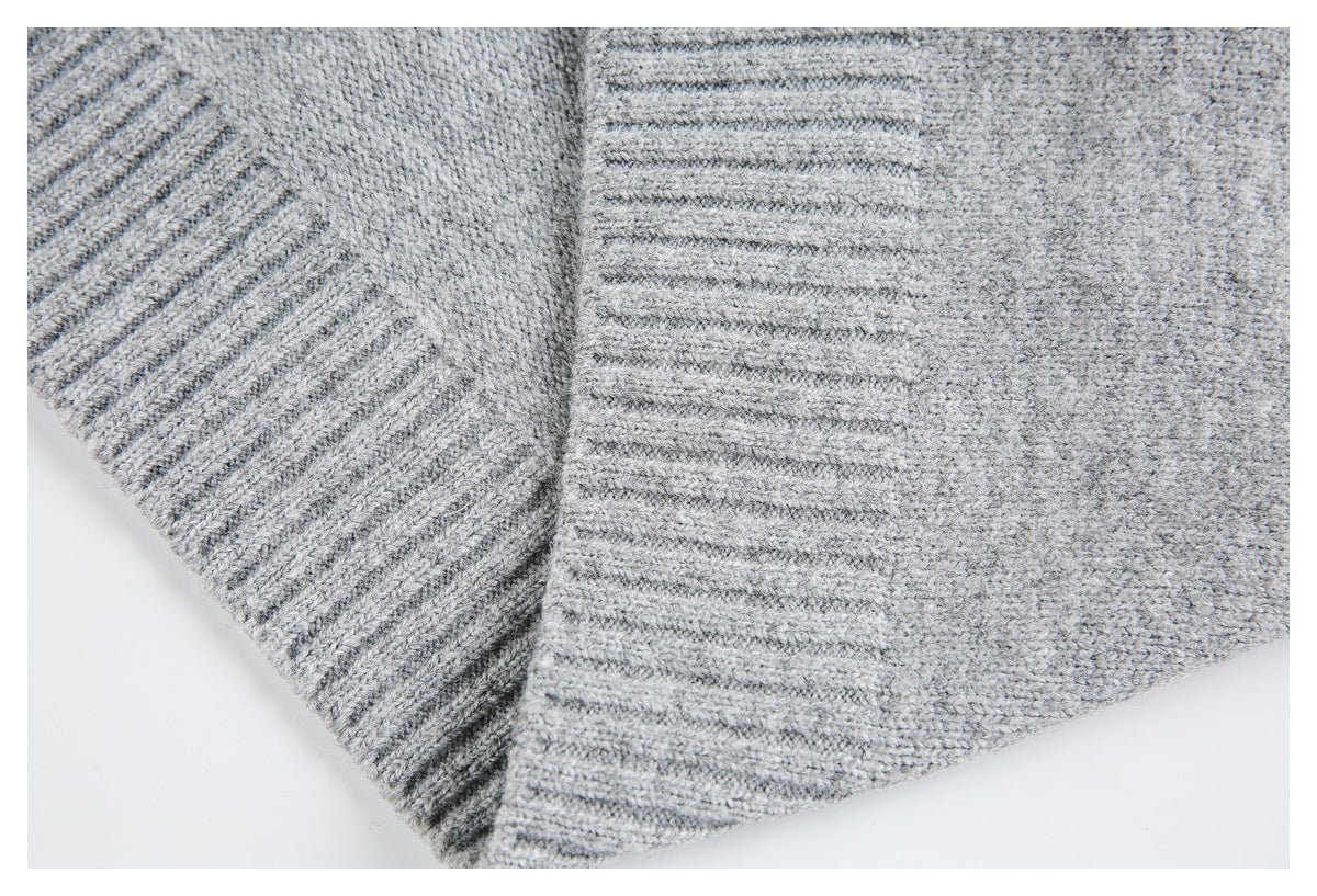 Close-up of light gray knit fabric with wide ribbed bands and a joining seam.