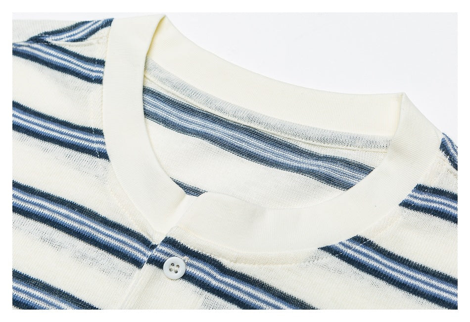 Close-up of an ivory crew neckline and button placket with navy and pale blue stripes.