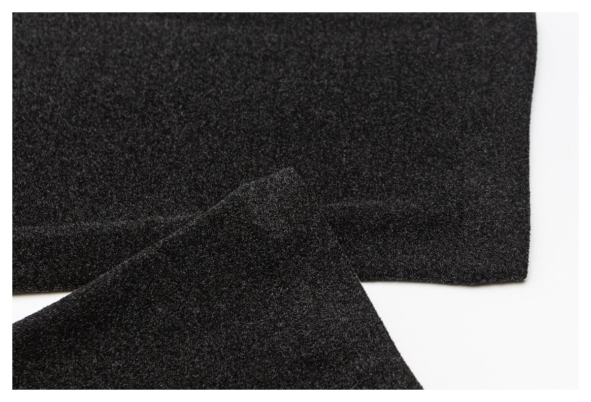 Close-up of dark charcoal fabric pieces with overlapping edges and a neat finished edge.